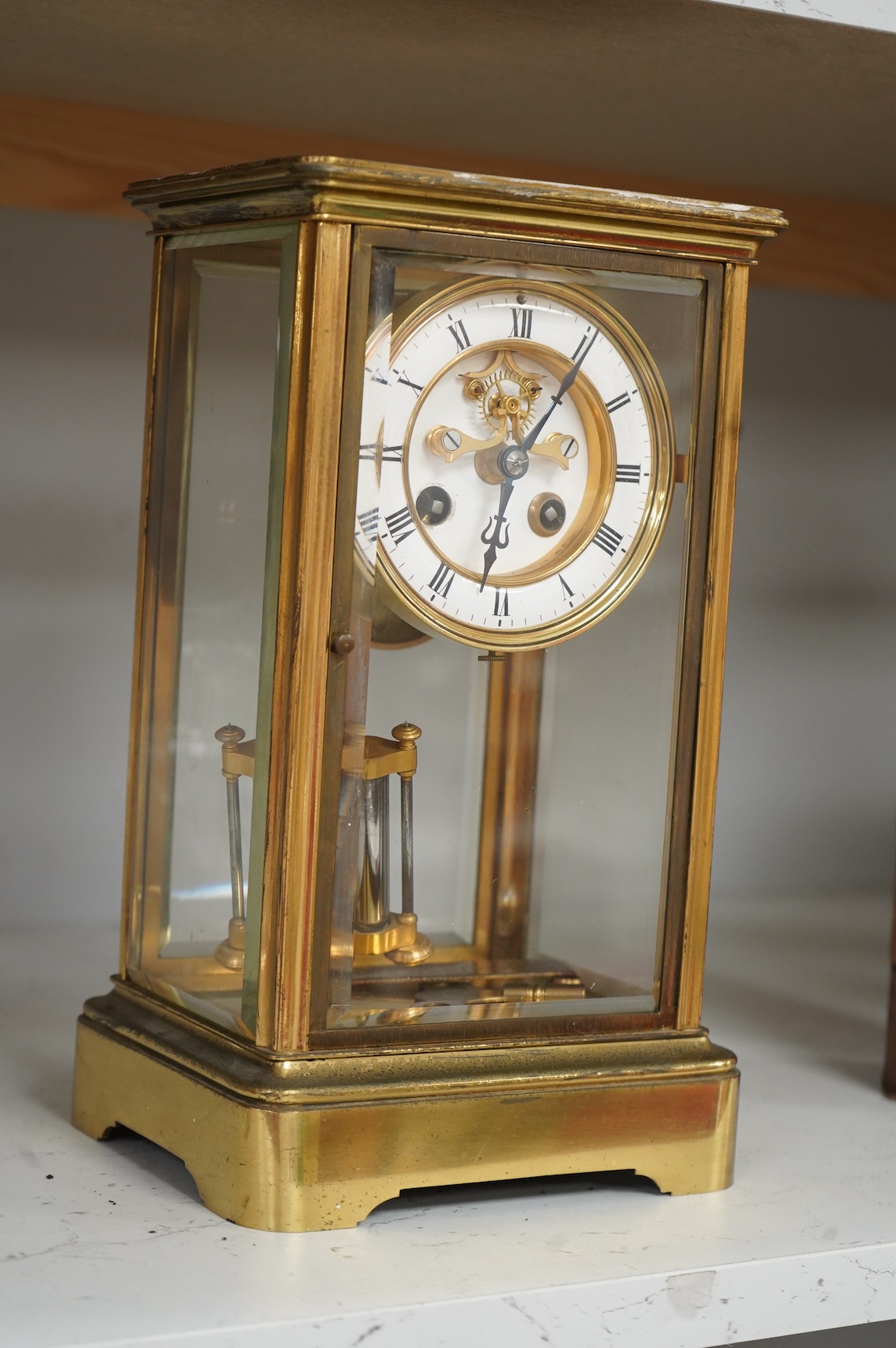 An early 20th century French brass and four glass mantel clock, striking on bell, with pendulum and key, 29cm high